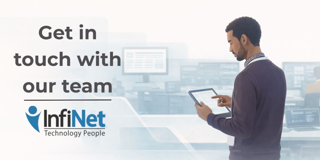 Flat-style digital illustration of an IT professional using a tablet in a calm, modern office. In the background, multiple workstations display structured system dashboards. Text reads: “Get in touch with our team.” InfiNet logo shown.
